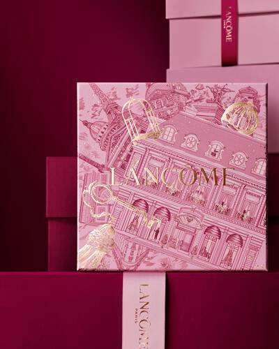 Елегантна поредица от розови и тъмнобордо подаръчни кутии Lancome, с централна кутия, украсена със златни илюстрации на парижката архитектура.