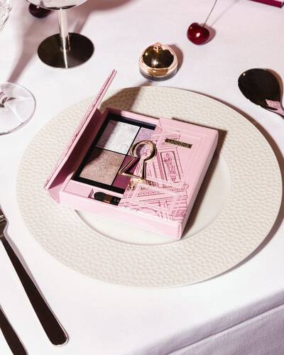 Розова палитра сенки за очи Lancome със златен мотив на ключалка, елегантно сервирана върху бяла празнична чиния.