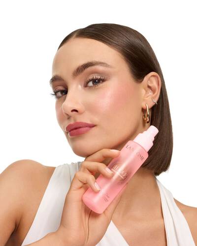 Жена с елегантен боб държи мъглата Lancome Idole.