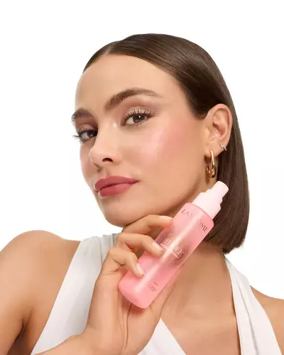 Жена с елегантен боб държи мъглата Lancome Idole.