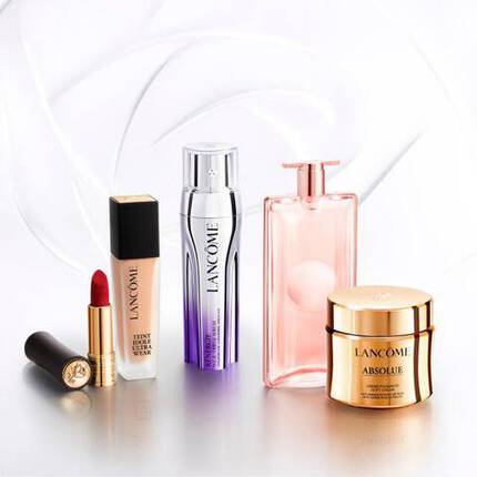 Изображение на козметични продукти от марката Lancome, включващо основа, червило, серум, парфюм и крем.