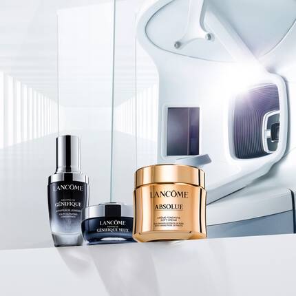 A display of Lancome skincare products, including a serum and cream, arranged elegantly with a modern, reflective background.
