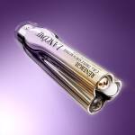 Жена с ясна кожа и светли очи, до бутилка серум на Lancome на фона на нежни линии.