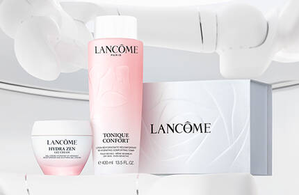 A well-lit display of Lancome skincare products, including a pink toner, a cream, and a box, all positioned on a sleek, white background.
