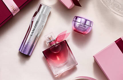 Празнични подаръчни комплекти Lancome в розови кутии в ретро стил на фона на снежни планини.