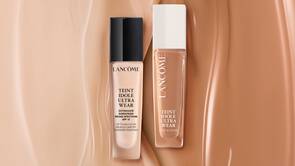 Два флуида за лице от марката Lancome, представени в различни нюанси от бежово.