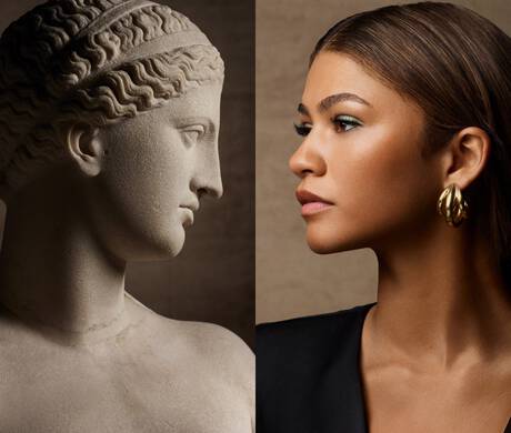 A split image featuring a classical marble sculpture of a woman's profile on the left and a contemporary portrait of a woman with sleek hair and gold hoop earrings on the right. Both figures share a similar profile and striking features, creating a dialogue between ancient and modern beauty.