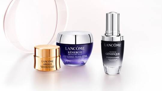 Три козметични продукта на Lancome: крем, серум и овлажняващ крем на светъл фон.